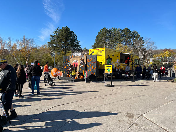 A line of people excited to get into a Halloween truck and display at the front of the Zoo